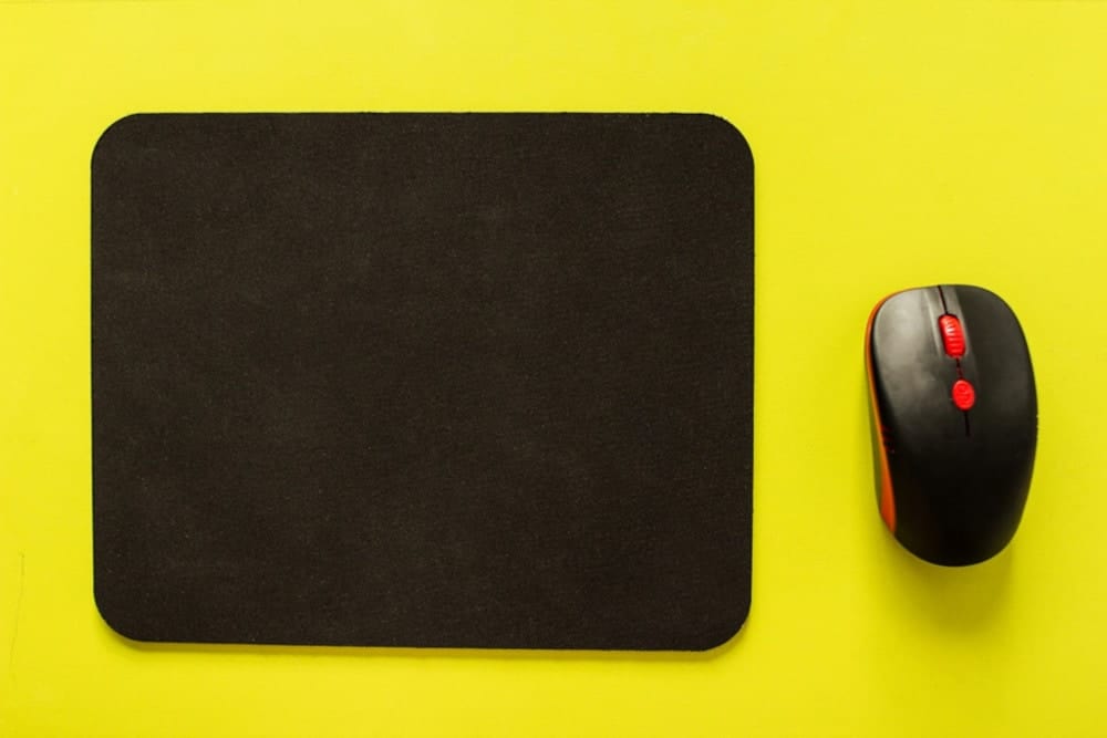 Black mousepad on a yellow surface