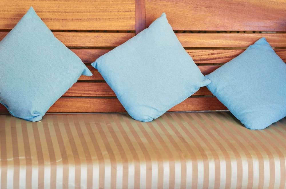 A row of blue pillows on a bench cushion