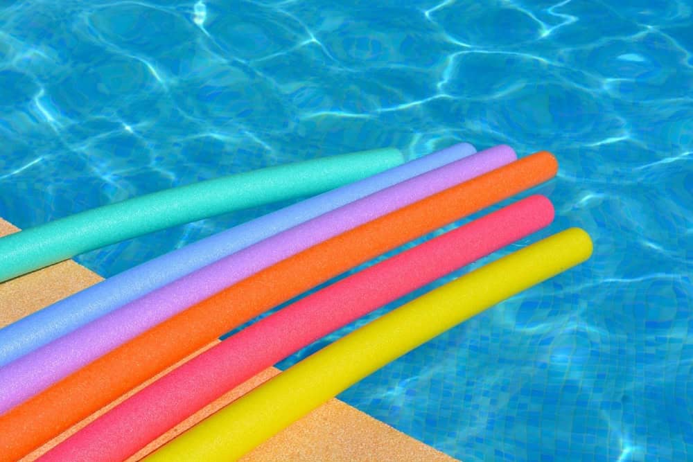 Foam pool noodles by pool side
