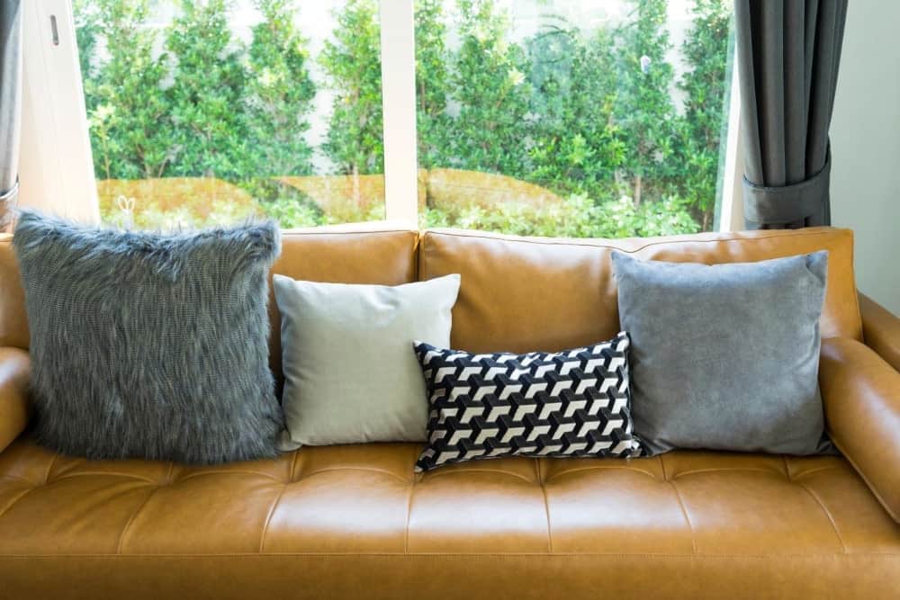 Couch with leather cushions and various throw pillows