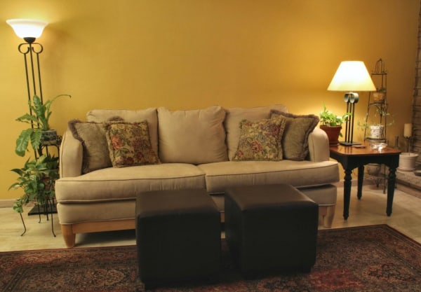 Room with lamps and a tan microfiber couch with pillows and cushion