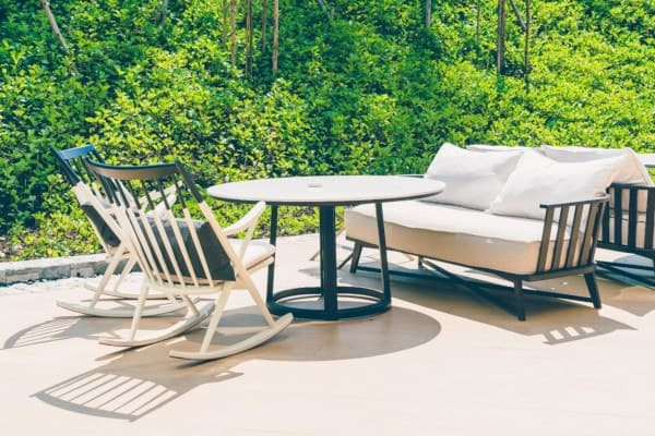 Rocking chairs and sofas with cushions on an outdoor patio