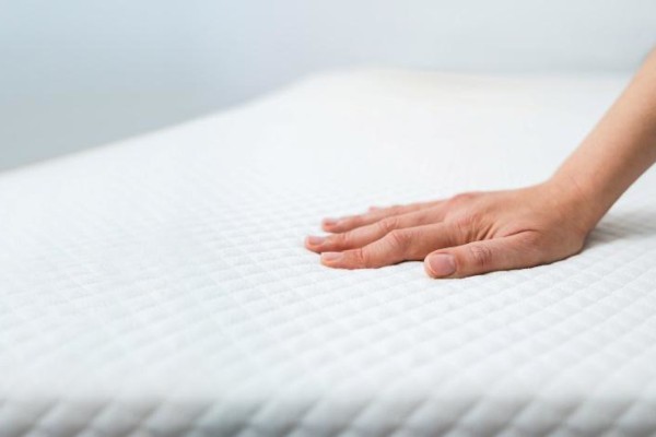 Hand pressing on memory foam mattress