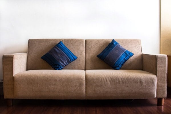 Brown couch with blue throw pillows
