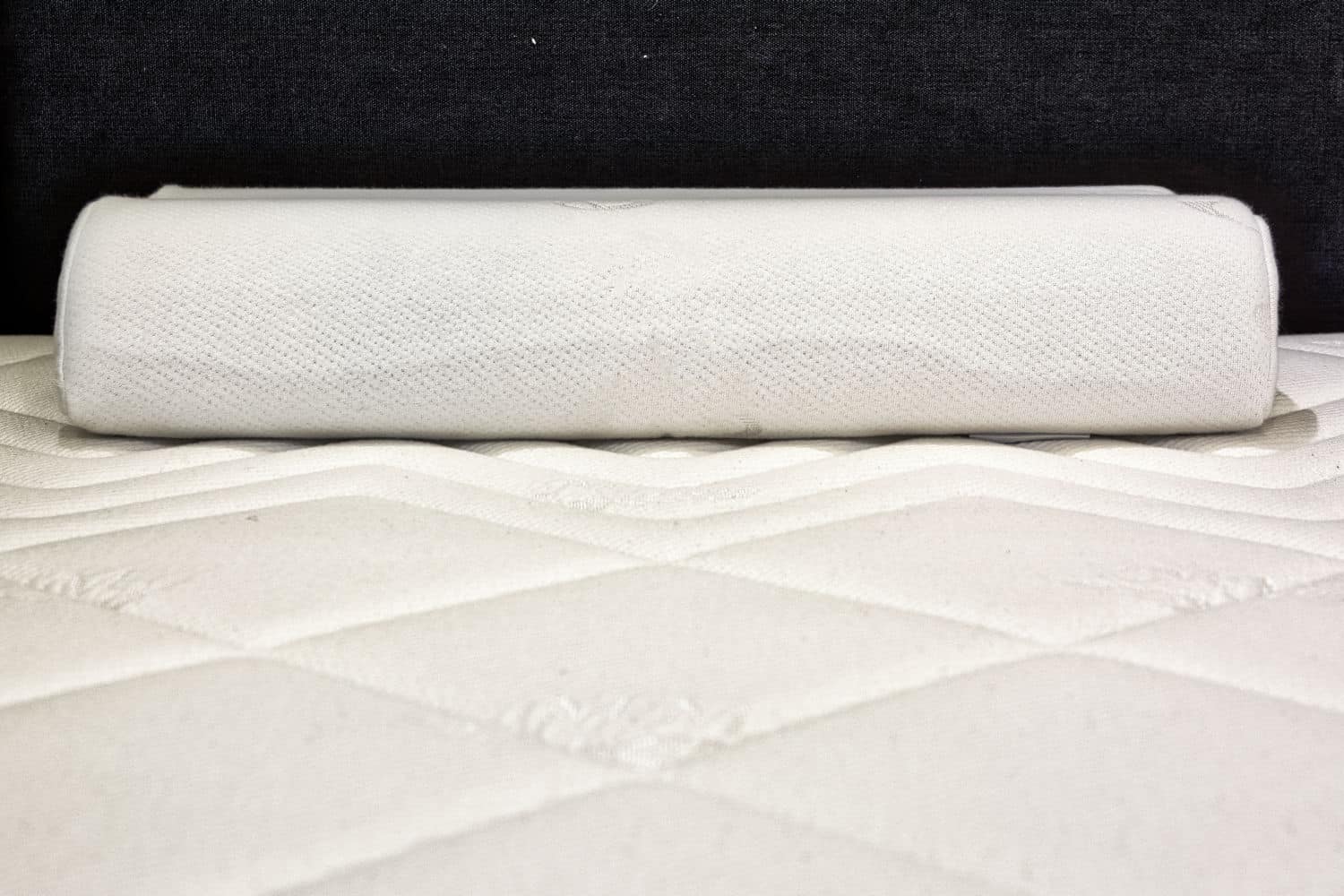 White sleeping pillow sitting on top of white mattress