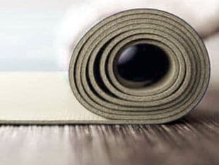 Beige thin foam partially rolled up on wood flooring