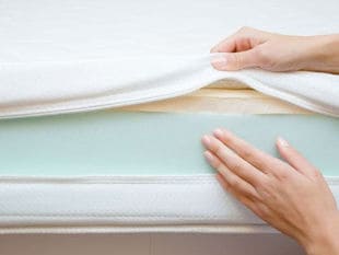 White Mattress Cover unzipped to reveal blue foam inside