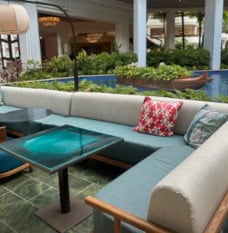 Wicker couches with yellow cushions on deck in front of fireplace