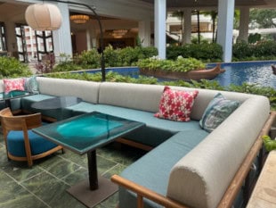 Wicker couches with yellow cushions on deck in front of fireplace