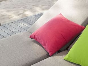 Bright pink and green pillows on tan lounge chairs