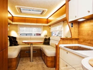 White booth cushions surrounding table in RV