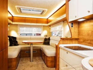 White booth cushions surrounding table in RV