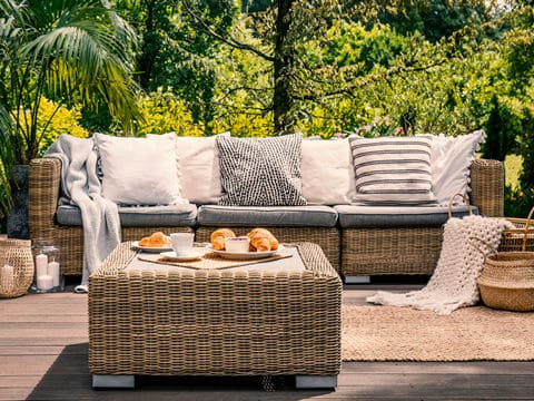 Wicker Couch with Grey Cushions in the Garden