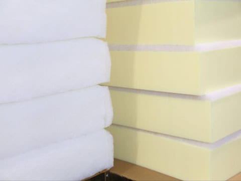 Dacron wrapped foam cushions stacked on a table