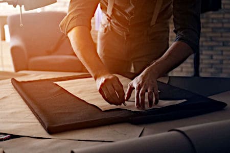 Man marking fabric for a custom sewing cushion cover