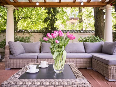 Outdoor patio with furniture with tulips and cups on a coffee table