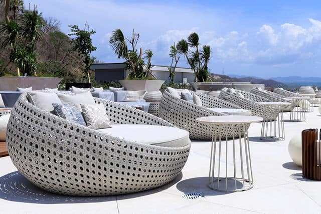 Outdoor row of round chairs with gray cushions and pillows