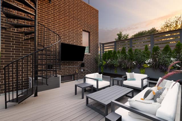  Black metal patio furniture with white cushions on a deck in front of a brick wall