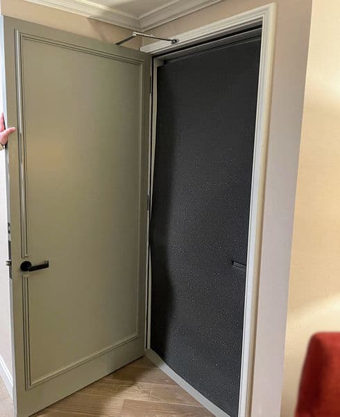 Open hotel door showing soundproofing foam between connected rooms