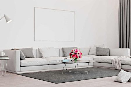 White living room with grey couches, rug, and curtains