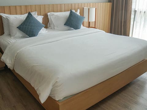 Wooden Bed with White Mattress, Bedsheet, and Pillows