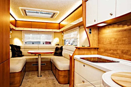 White booth cushions surrounding table in RV