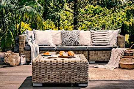 Wicker Couch with Grey Cushions in the Garden